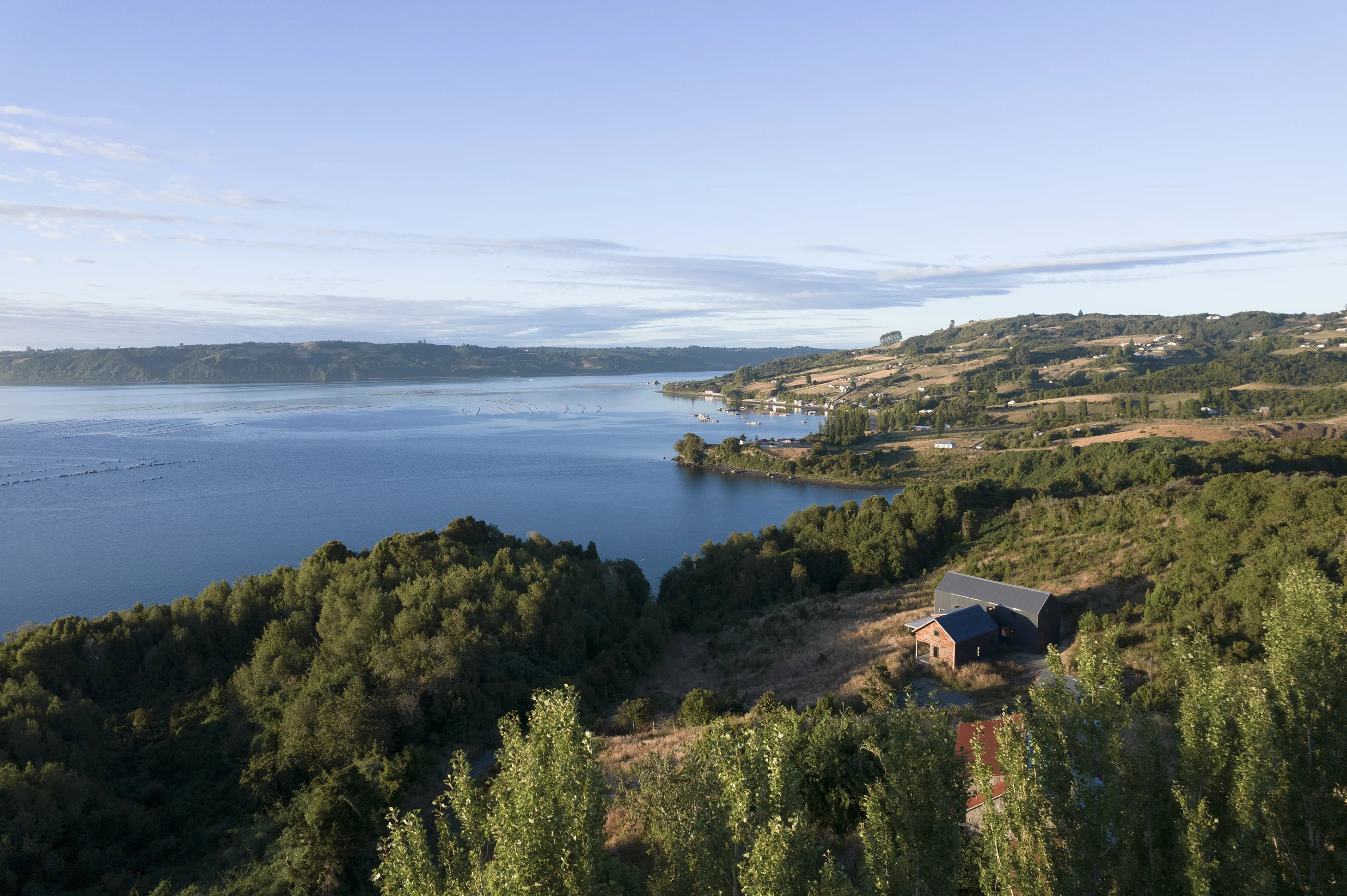 Vivienda en madera de Constructora Patrimonial Chiloé junto al lago, vista aérea en Quetalco